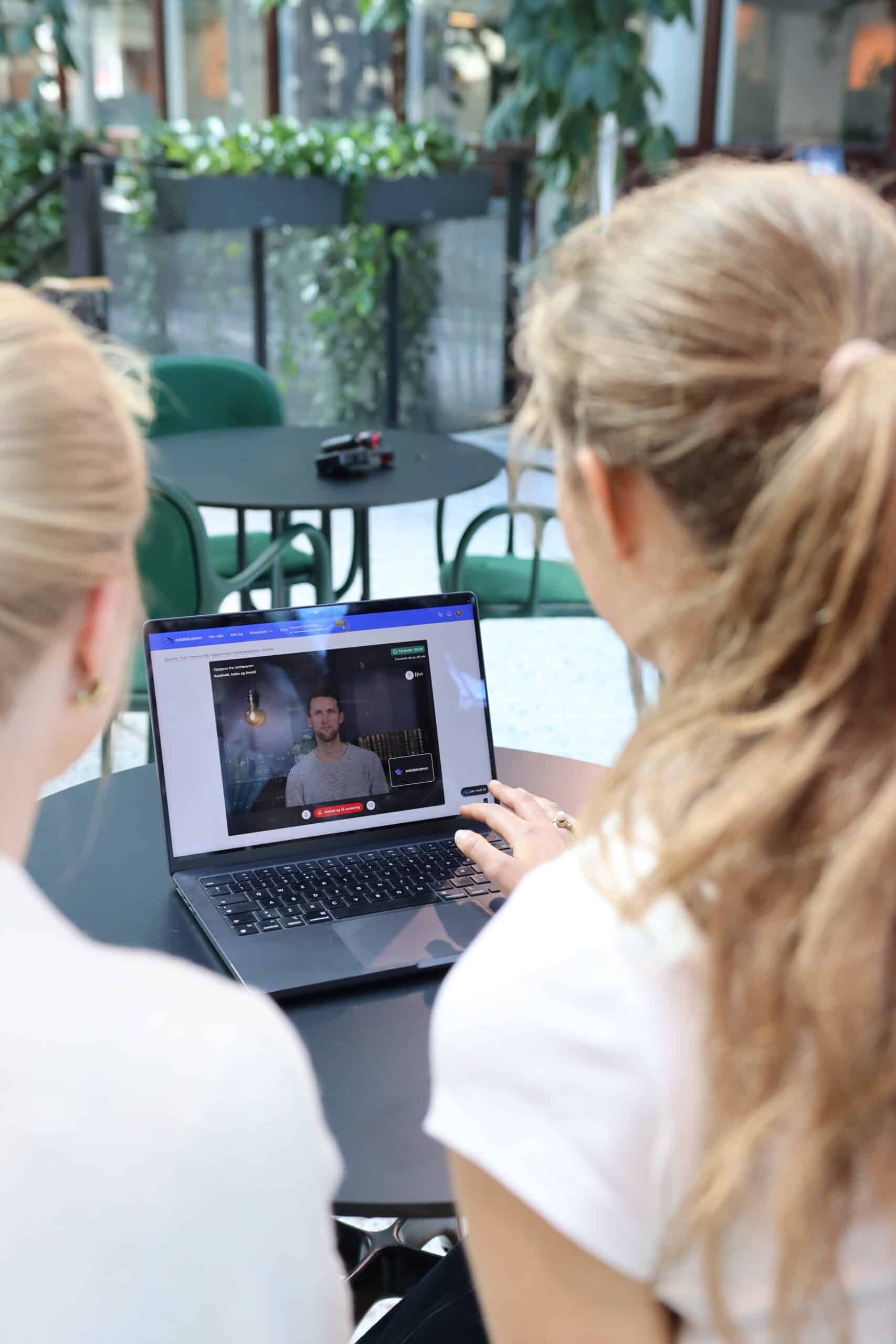 Ser over skulderen på privatister som bruker EnkelEksamen-plattformen på skjermen (videoleksjon).