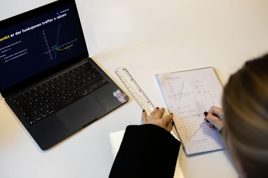 Student løser eksamenoppgaver for hånd med undervisning på video